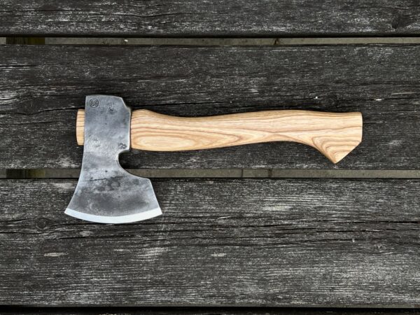The Sloyd carving axe hand-forged for spoon carving and green woodworking on a table